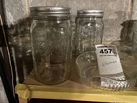 Ball mason jars with metal lids beside small clear glass dish