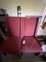 Front view of both red burgundy upholstered Parsons dining chairs
