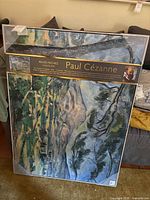 Front view of framed Cézanne canvas print with retail label and protective corners visible