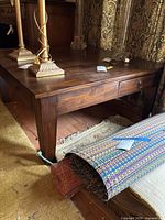 Overall view of coffee table showing square top, legs, drawer