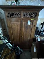 Front view showing carved panels, two doors, overall condition