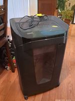 Front view of shredder showing body, window, casters, power cord