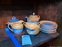 Full set showing teapot, creamer, covered sugar, stacked cups and saucers