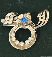 Front view of brooch showing blue center stone and clear rhinestones