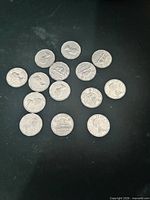Group of 14 Canadian nickel coins displayed on dark surface