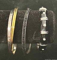 Four bangles on display rod showing overall styles and finishes
