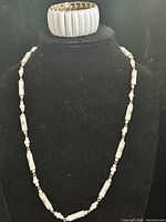 Necklace and stretch bracelet displayed on bust
