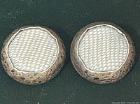 Front view of both earrings showing white textured centres and silver-tone rims