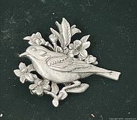 front view of silver-tone bird and floral brooch