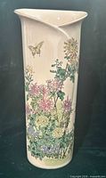 Front view showing floral and butterfly motif on cream tall vase
