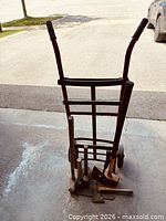 Front view of hand truck with tools standing against it