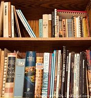 Two shelves of assorted cookbooks showing spines