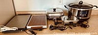 Group shot of all appliances: two warming trays, two skillets, slow cooker