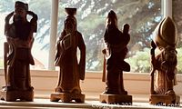 All four carved wooden figurines lined up in window light