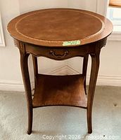 Front view highlighting leather top, drawer pull, cabriole legs