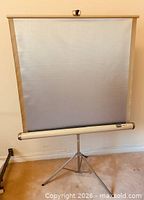 Screen fully extended on tripod stand showing silver surface and overall condition