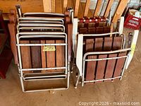 Two stacks of folded lawn chairs showing wood slats and aluminum frames