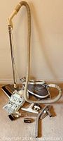Full view of vacuum body, hose, wand and multiple attachments