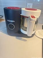 Front view of Béaba Babycook showing base, control dial, glass jar and handle