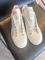 Top view of both sneakers showing lacing, tongue label, custom eyelet design