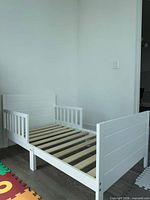 Full view of assembled white toddler bed frame
