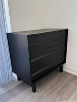 Front view of black 5-drawer dresser