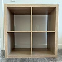 Front view showing four equal compartments and light oak finish