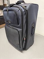 Front view of navy Samsonite suitcase showing pockets and logo
