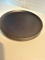 Stack of three black dinner plates viewed from above