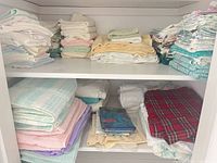 Upper shelf showing stacks of pastel towels, white towels and teal towels