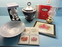 Group shot showing all items: bowl, chafing dish, two oil lamps, Pimpernel coasters and placemats
