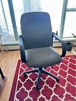 Front angled view showing upholstery, arms, base and casters