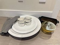 Group shot of all items: two platters, four ramekins with lids, glass bowl, cast-iron dish, napkin