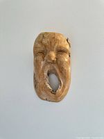 Front view of carved wood mask on wall
