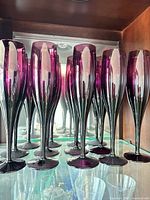 Front view of purple glass flutes on shelf