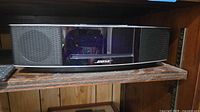 Front view of Bose Wave Music System IV and remote on shelf