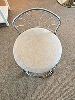 Top view showing beige upholstered round seat and chrome backrest