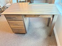 Top and drawer pedestal view showing 3-drawer side, wood grain, metal pulls