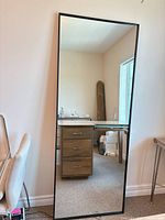 Front view of the full-length mirror leaning against wall