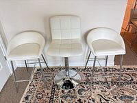 Front view of all three stools lined against wall