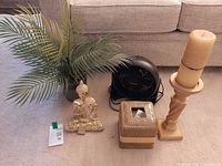 All five items grouped: fan, faux palm, Buddha statue, tissue box cover, pillar candle on pedestal
