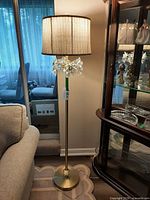 Full view of floor lamp beside furniture and cabinet