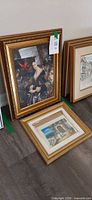 Both framed artworks leaning on wall, showing relative sizes and frames