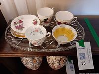 Overview of crystal tray and four teacup/saucer sets