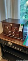 Closed espresso wood jewelry chest on table