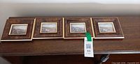Four framed prints lined up on shelf