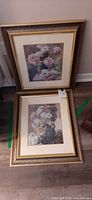 Both framed prints leaning against wall