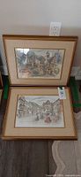 Both framed watercolor prints leaning against wall showing size and framing