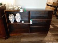 Front view of dark-stained wooden bookshelf showing four open compartments