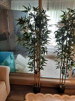 Full view of the artificial bamboo plant standing by window